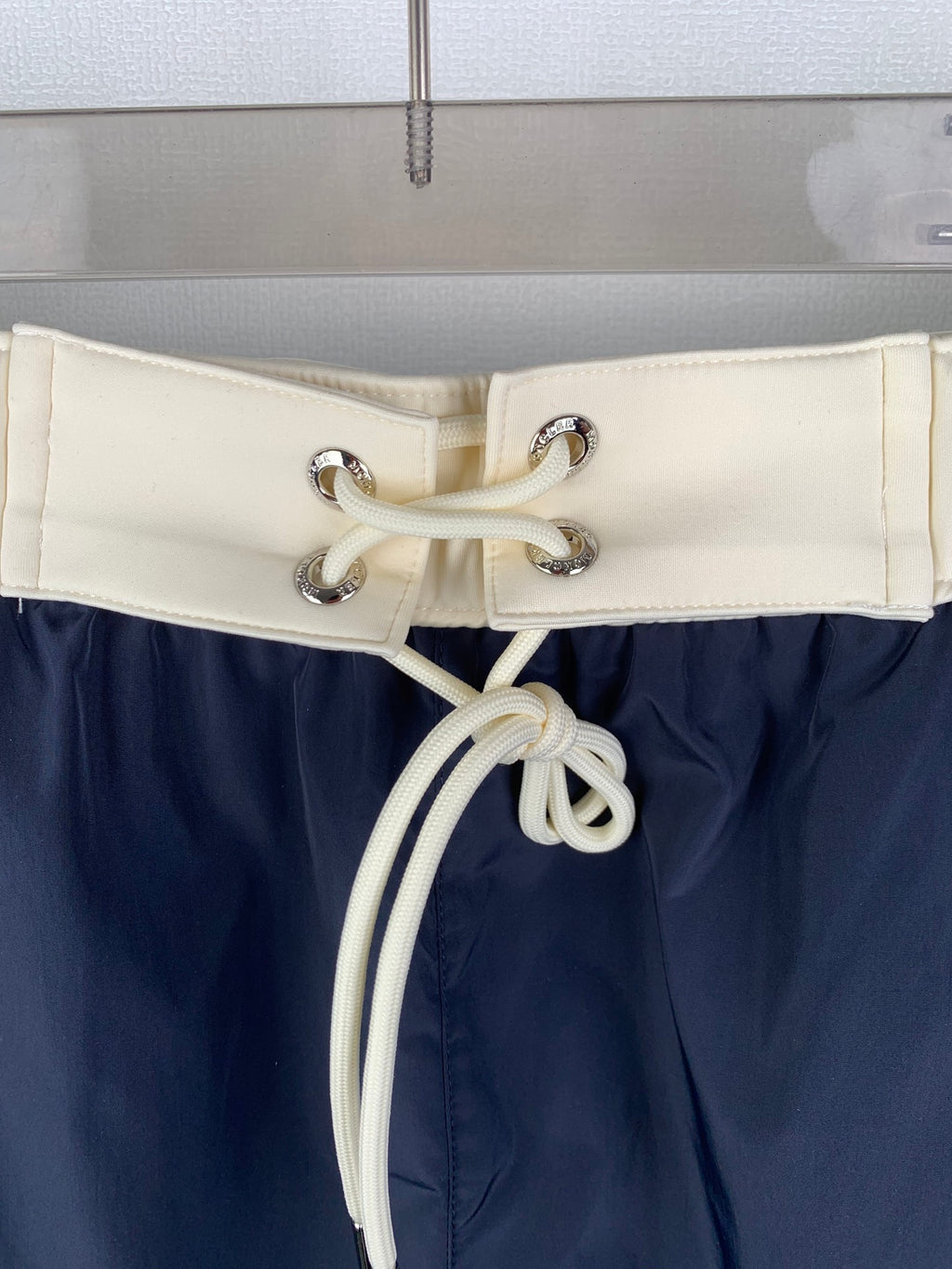 Moncler off-white drawstring waistband with metal eyelets on navy pants