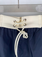 Moncler off-white drawstring waistband with metal eyelets on navy pants