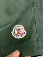 Moncler logo patch on green shorts with side seam and stitching
