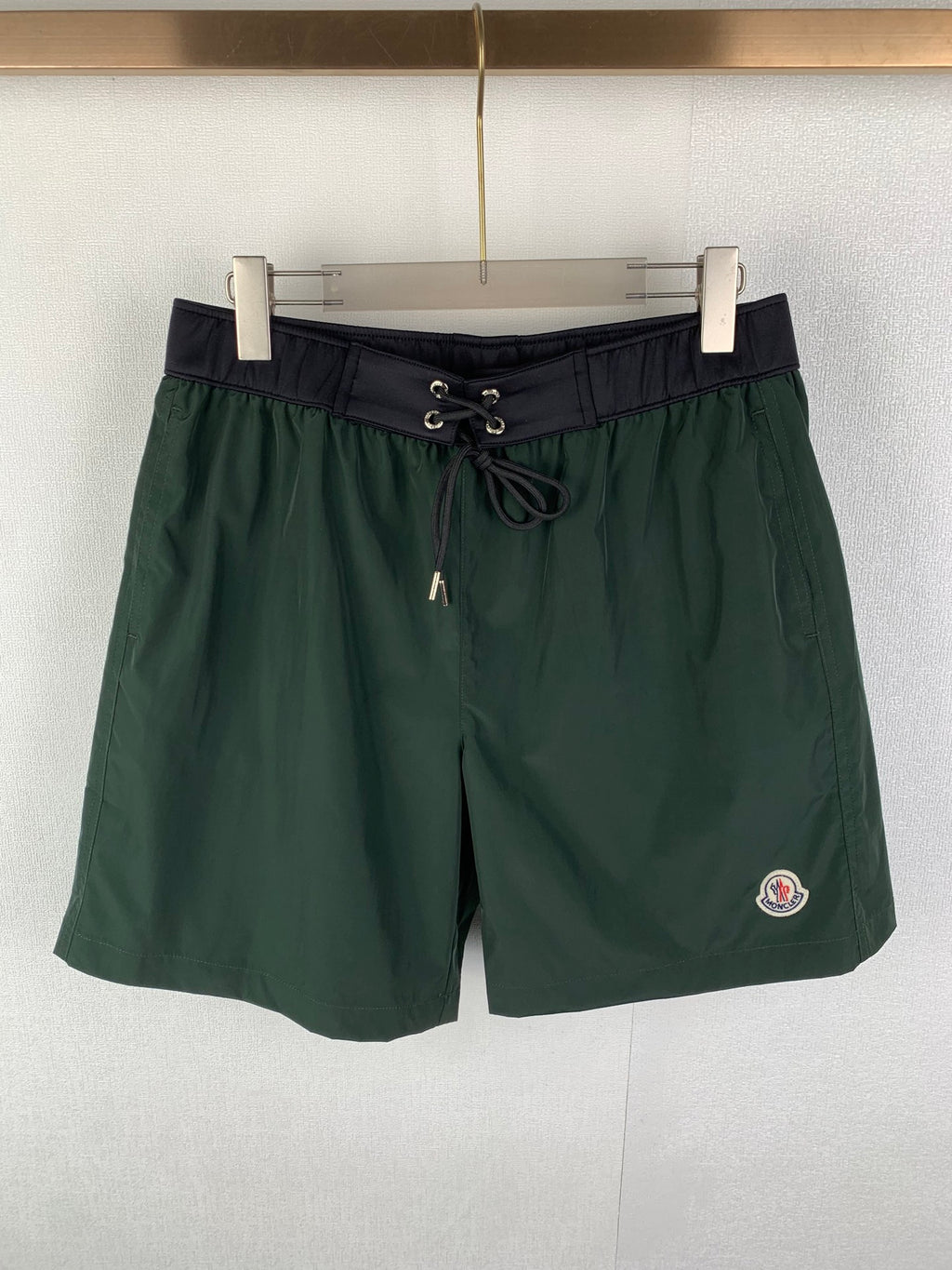 Moncler green drawstring shorts with dark waistband and side logo patch