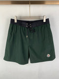 Moncler green drawstring shorts with dark waistband and side logo patch