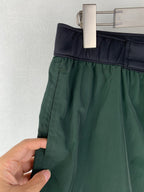 Moncler green shorts with dark elastic waistband and side seam stitching