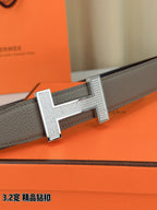Hermes belt buckle close-up on gray leather strap with silver-tone H hardware