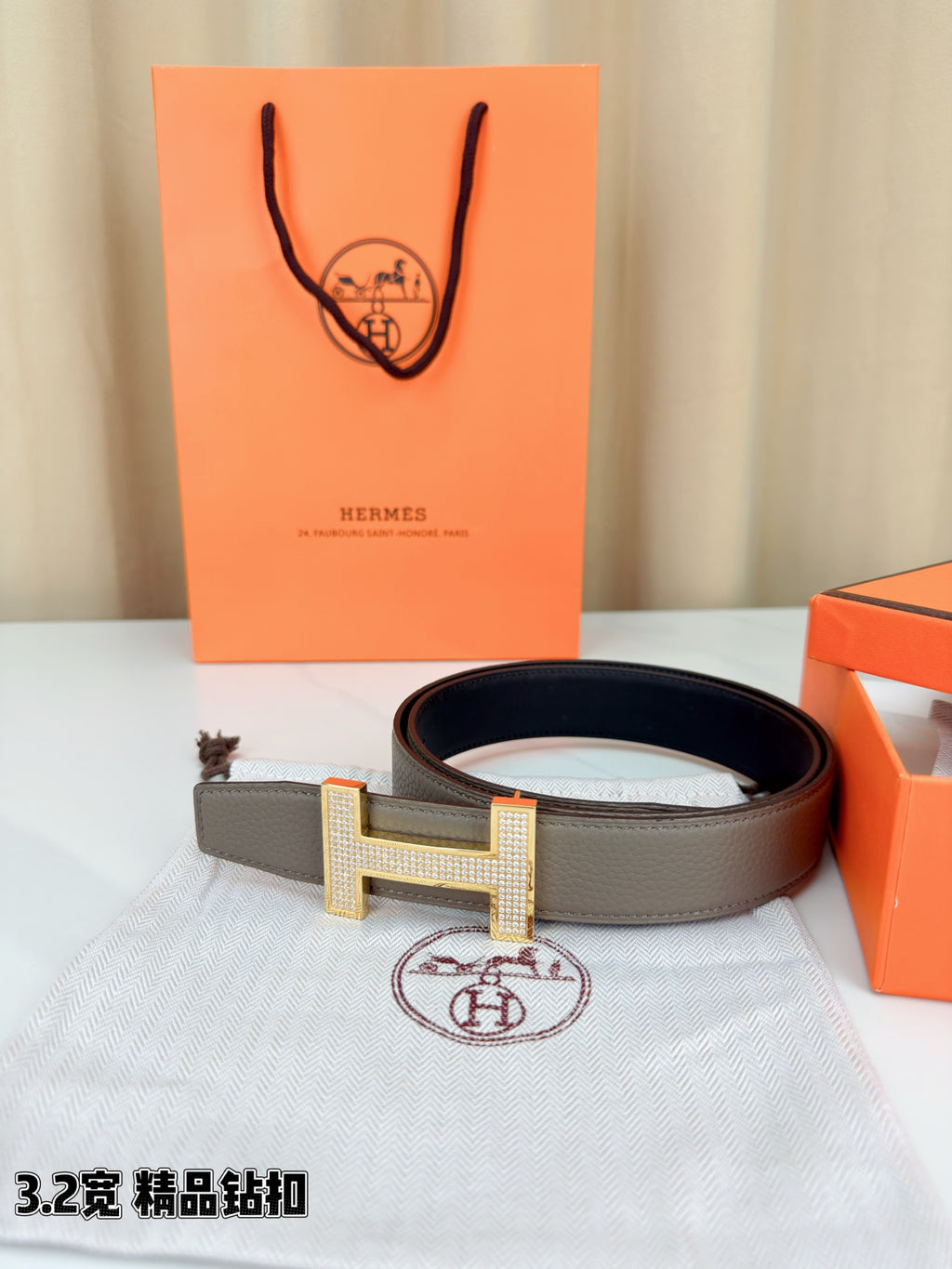 Hermes belt with gray leather strap and gold-tone H buckle with textured surface
