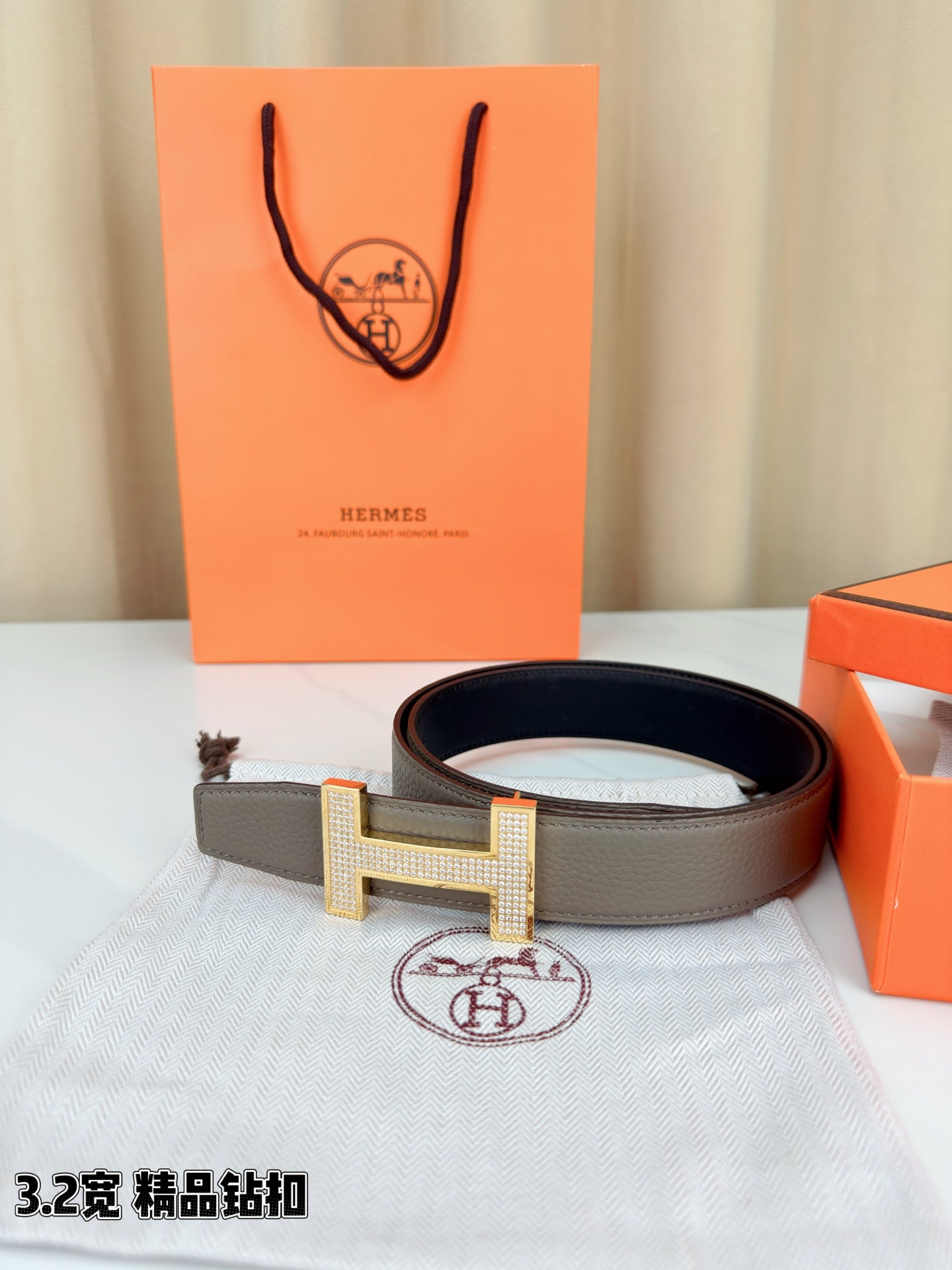 Hermes belt with gray leather strap and gold-tone H buckle with textured surface