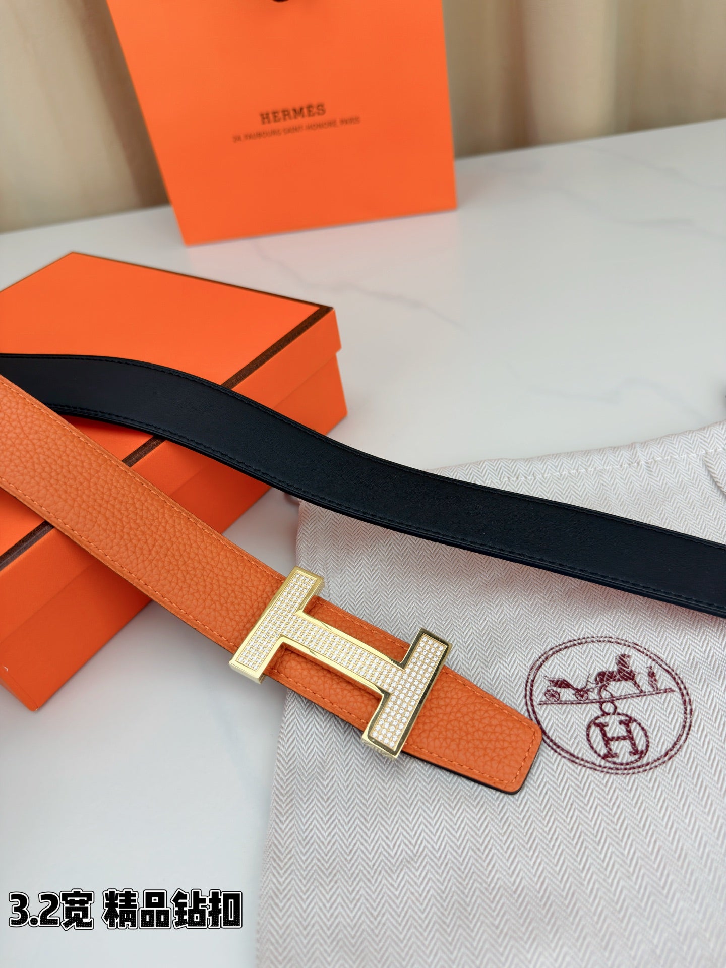 Hermes belt with orange leather front and dark strap, silver H buckle detail
