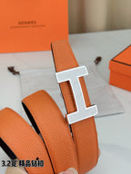 Hermes belt leather close-up: orange textured strap with silver H buckle