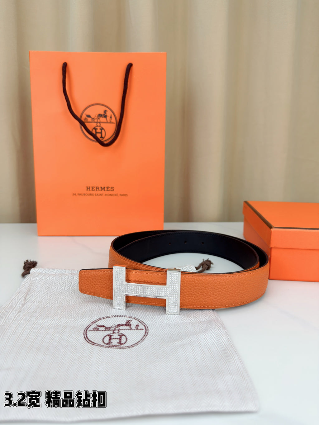 Hermes belt in orange textured leather with dark inner band and silver H buckle