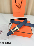 Blue leather belt with silver-tone H buckle laid flat with strap holes