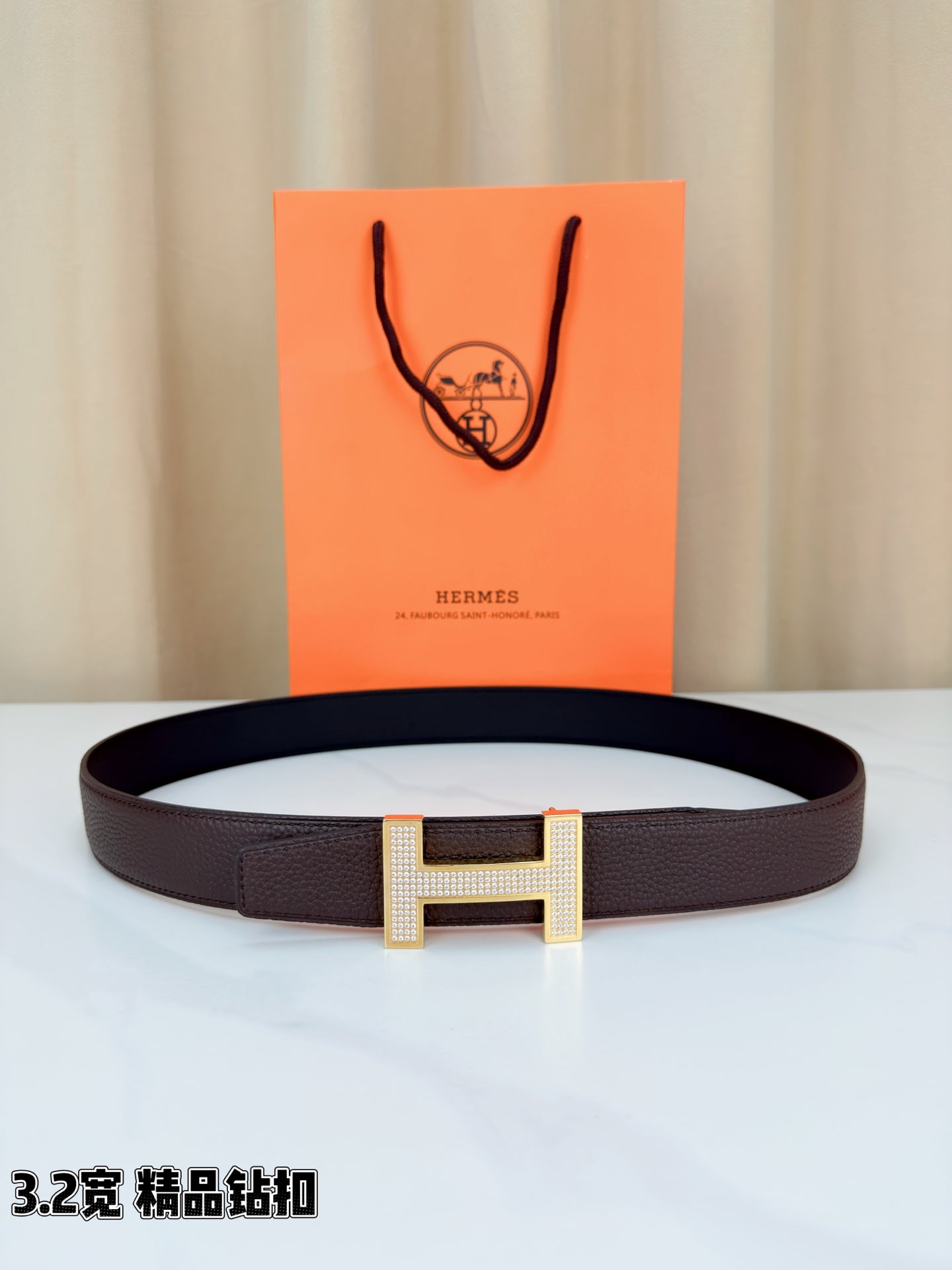 Dark brown leather belt with gold-tone H buckle and textured strap