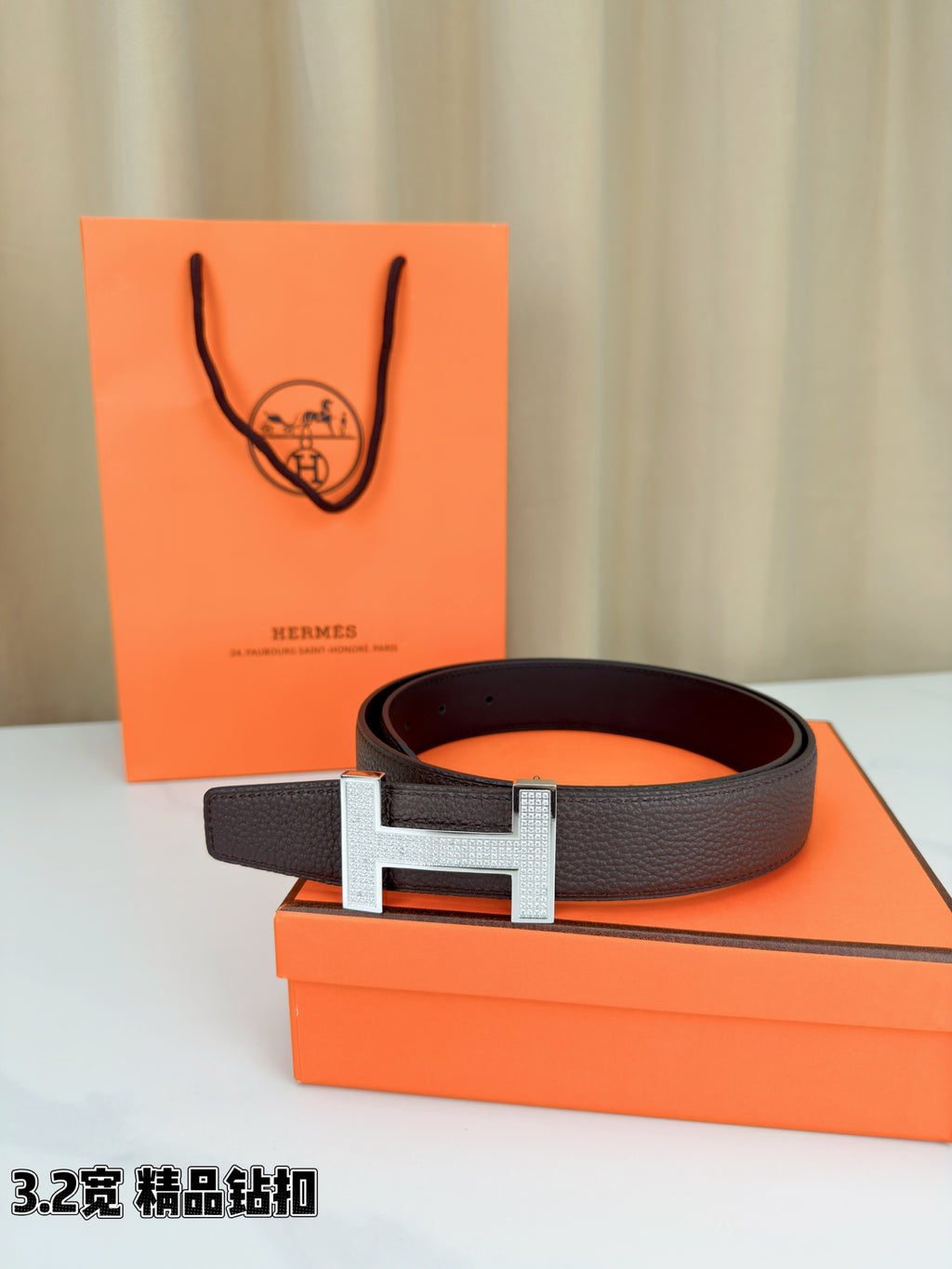 Dark brown leather belt with gold-tone H buckle on display
