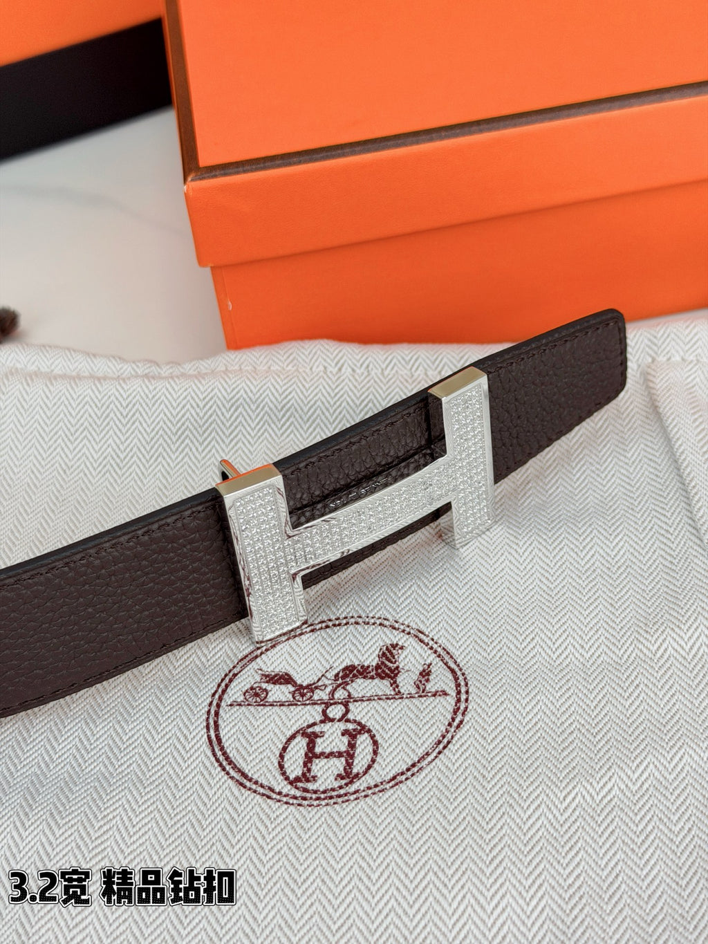 Dark brown leather belt with gold-tone H buckle in close detail