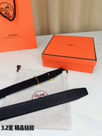 Hermes belt with dark leather strap and silver-tone H buckle, laid on dust bag