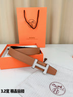 Tan belt with silver H buckle, open view showing black inner strap section