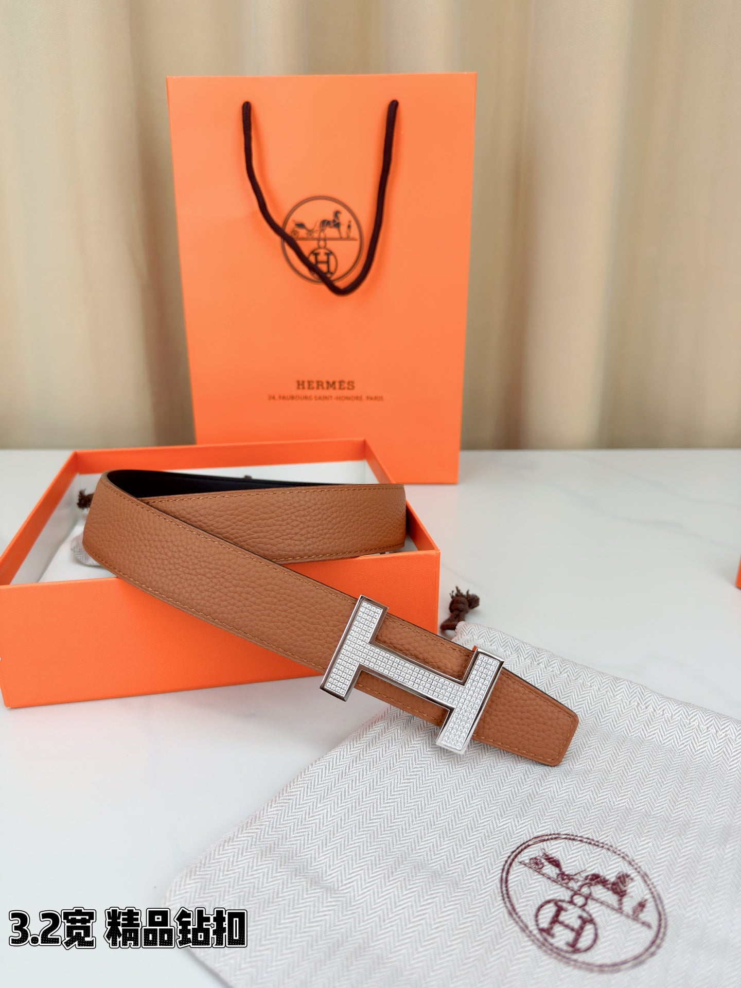Tan belt with silver H buckle, open view showing black inner strap section