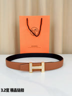 Tan leather belt with silver-tone H buckle and dark inner lining edge