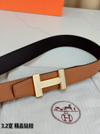 Tan belt with silver H buckle, textured leather strap and dark inner edge