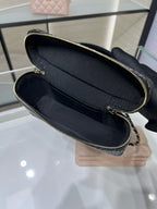 Black woven bag interior with navy lining and gold-tone zipper edge, close-up
