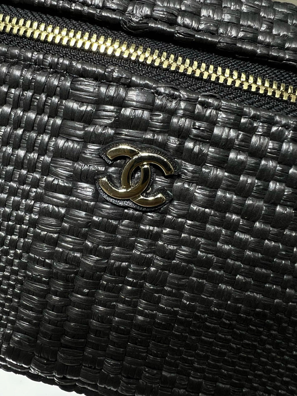 Black woven handbag with Chanel CC logo and gold-tone zipper detail, close-up