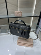 Black woven handbag with top handle, chain strap, and gold zipper closure, front