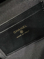 Black leather label on handbag reading CHANEL Made in Italy, gold lettering