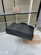 Black woven mini crossbody bag with chain strap and gold zipper trim, angled view