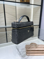 Black woven mini handbag with top handle, chain strap, and gold-tone logo plaque
