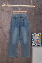 Blue denim pants with belt loops and front fly, hanging on wooden hanger.