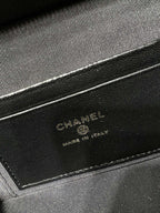 Close-up of black Chanel leather label reading CHANEL, made in Italy