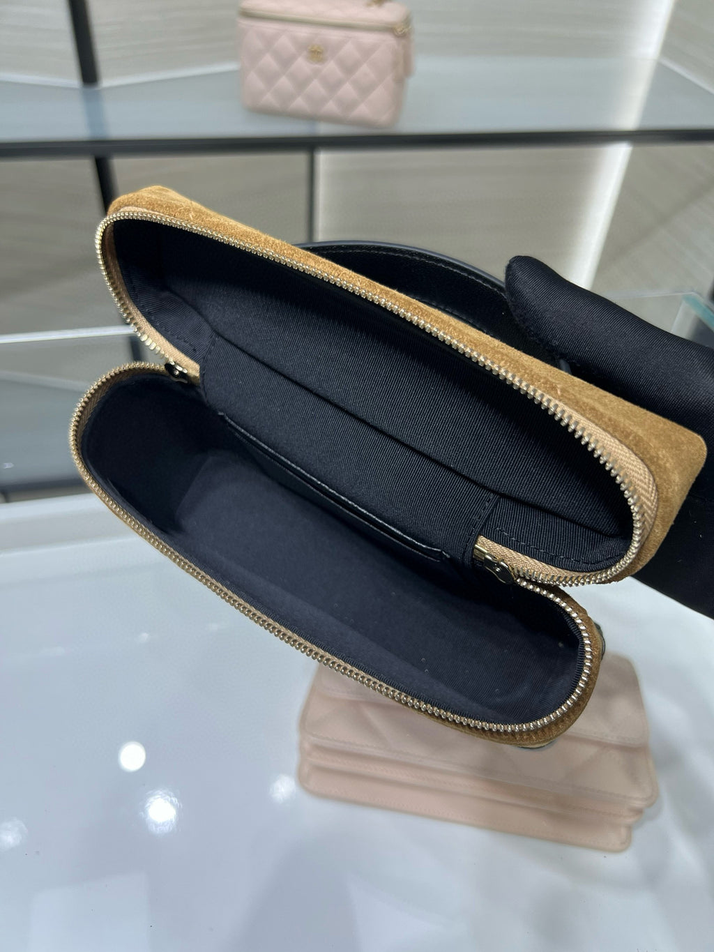 Open gold Chanel zip-top clutch with black interior and gold-tone zipper trim