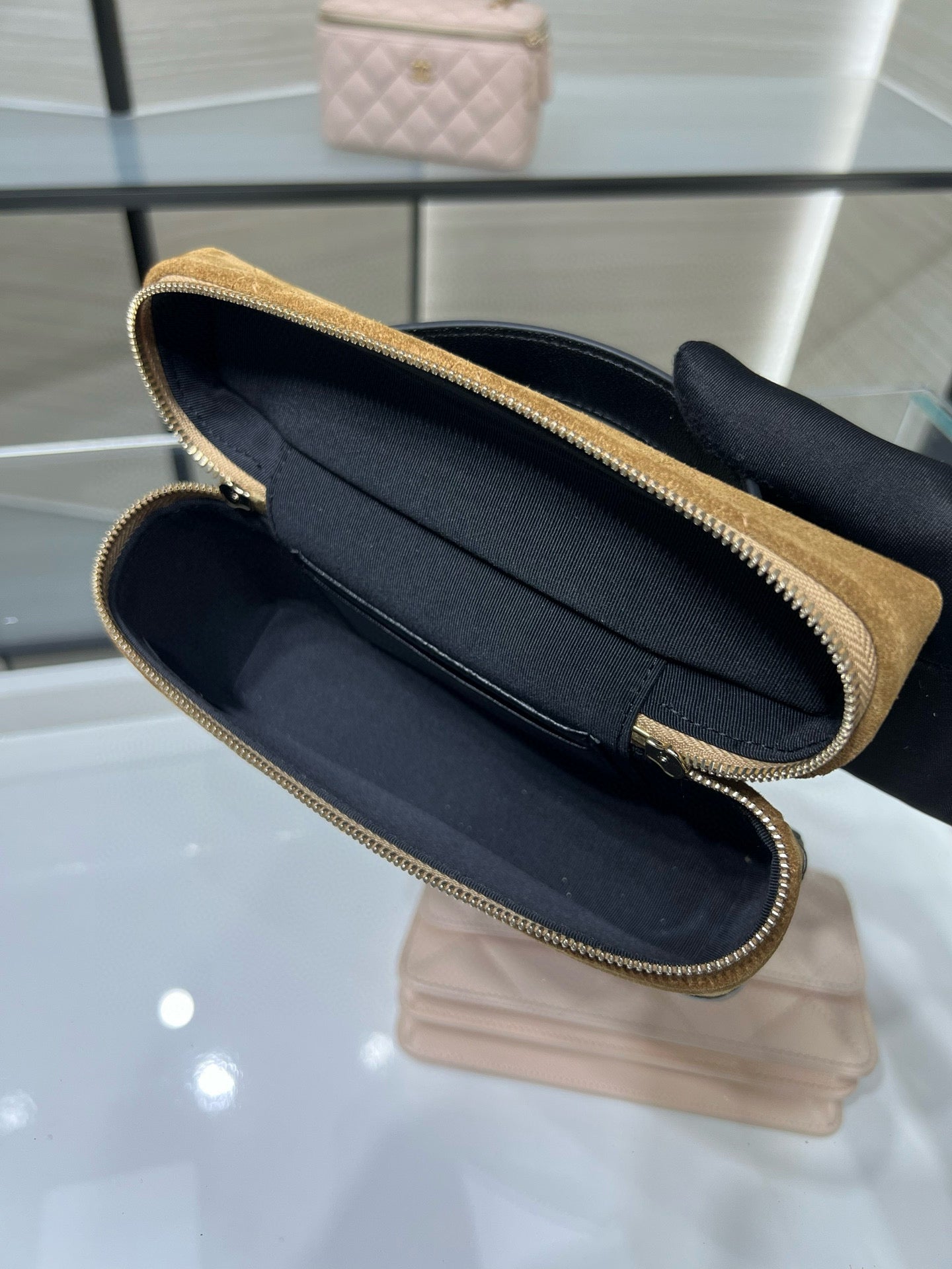 Open gold Chanel zip-top clutch with black interior and gold-tone zipper trim