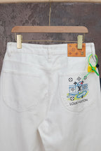 White denim pants with multicolor graphic patch on right pocket