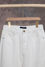 White denim pants front with button closure and waistband logo tag