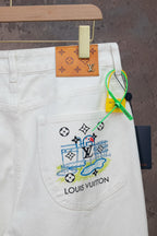 White denim pants with colorful emblem graphic on right pocket