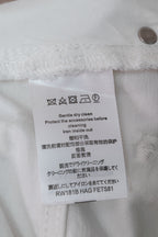 White denim pants care label with washing and ironing instructions