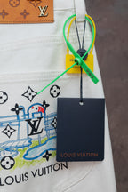 White denim pants with LV emblem print and hanging Louis Vuitton tag
