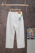 White denim pants with button fly and logo patch at right hip