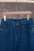 Blue denim jeans with logo patch, belt loops, and button closure