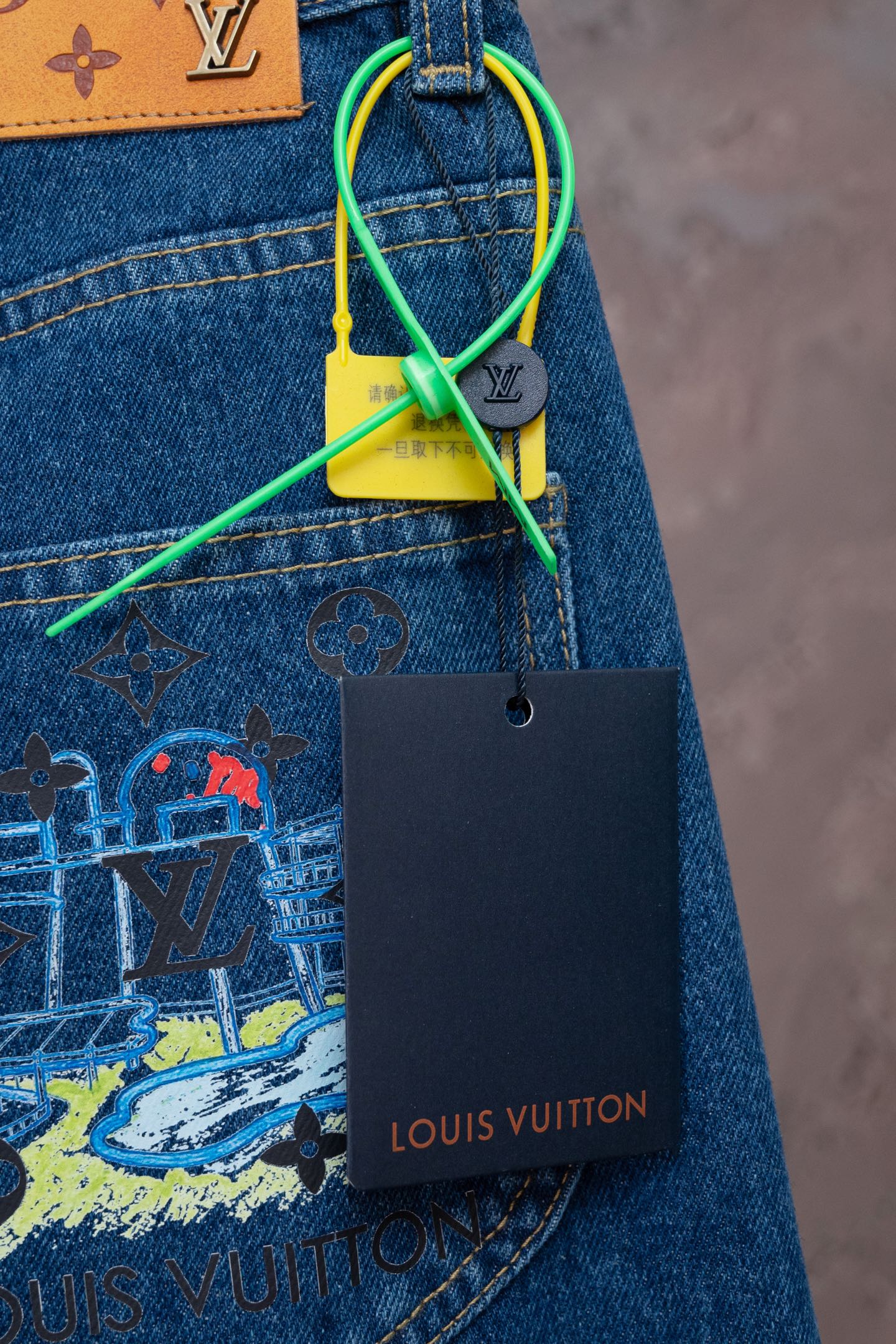 Blue denim jeans with back-pocket graphic and green string tag