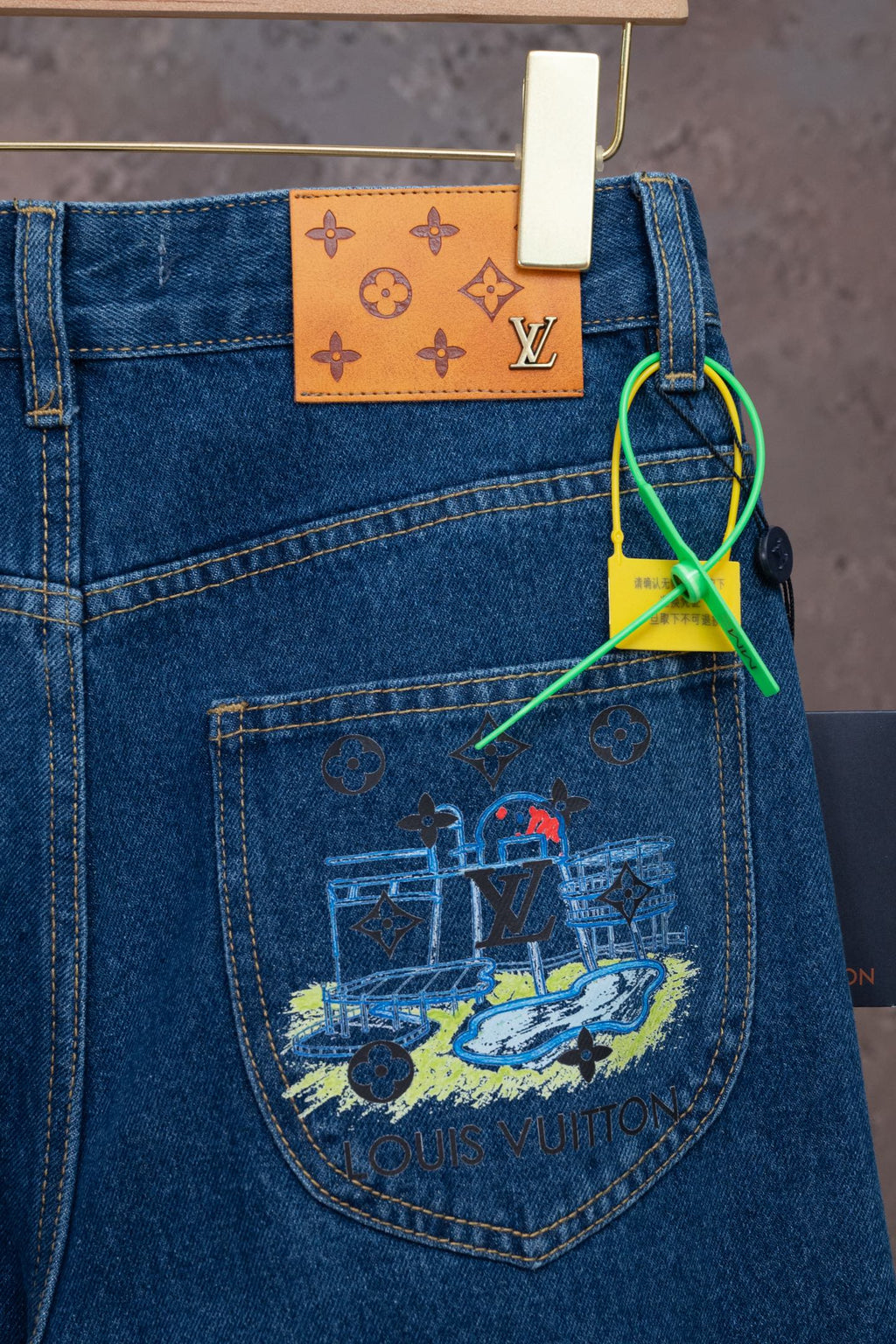 Blue denim jeans with colorful back-pocket graphic and hanging tag