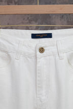 White Louis Vuitton pants close-up: logo waistband tag, button front and pockets