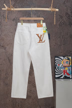 White Louis Vuitton pants on hanger with LV graphic patch on right pocket
