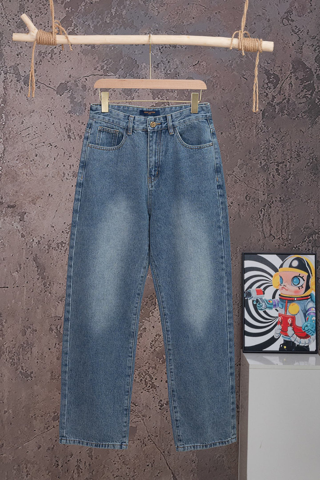 Light blue denim pants with waistband button, belt loops, and back patch