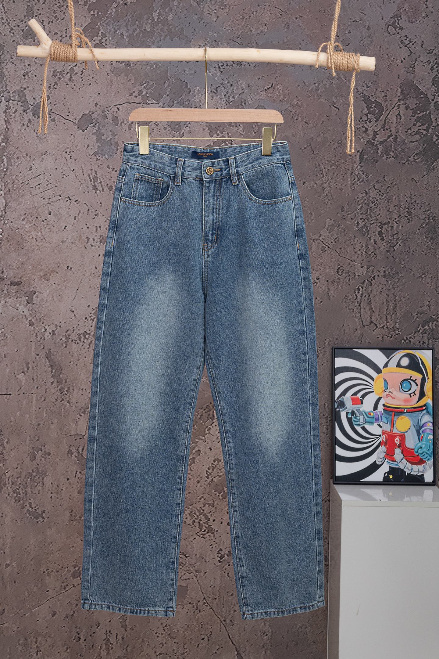 Light blue denim pants with waistband button, belt loops, and back patch