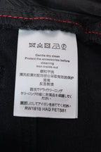 Care label on black denim pants with washing instructions