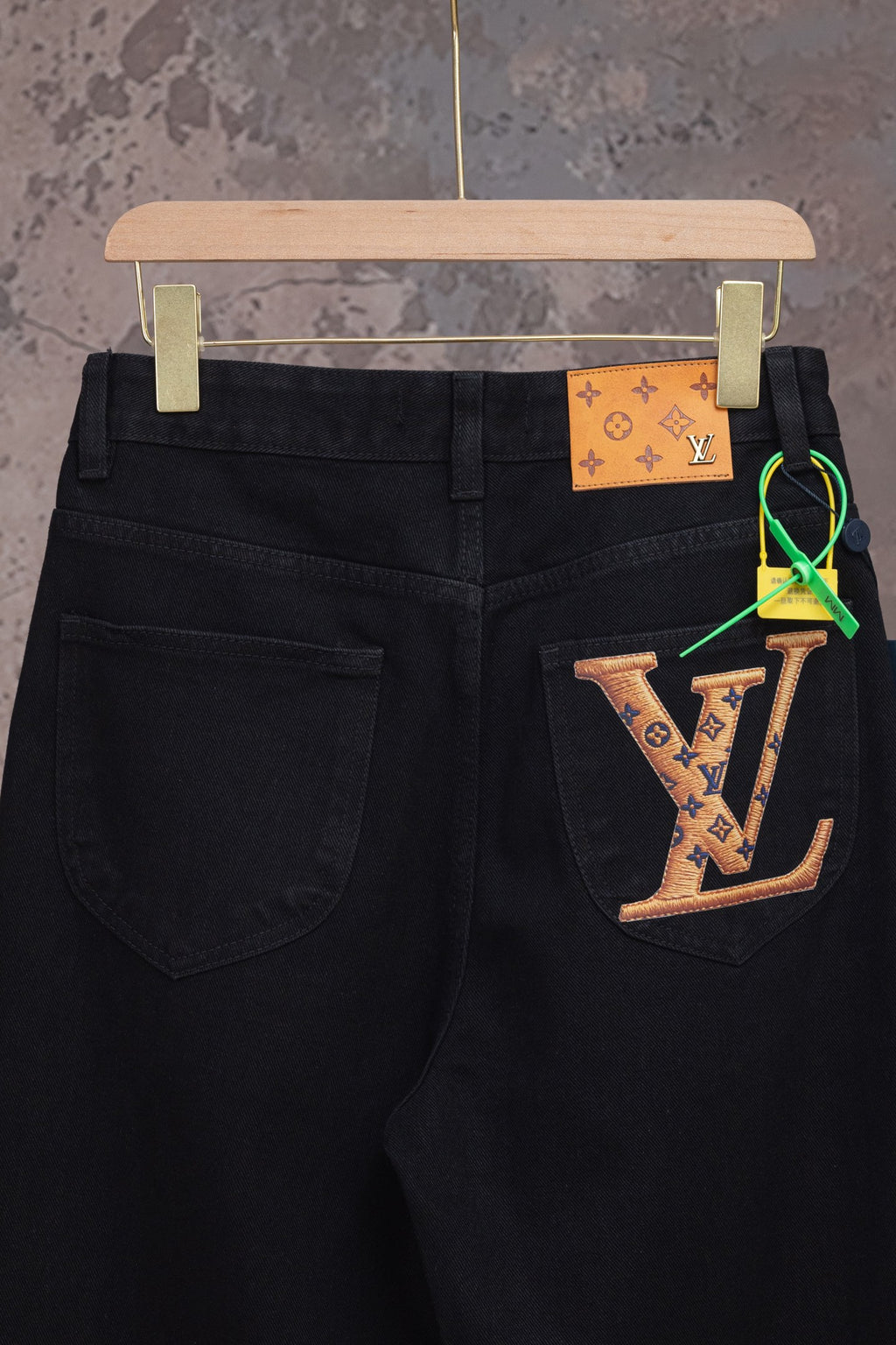 Black denim pants with front pockets and waistband button, with LV keychain detail
