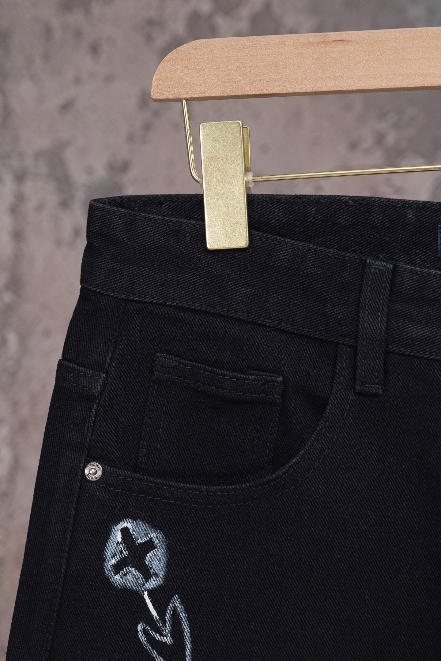 Black denim jeans with front pocket and embroidered emblem detail