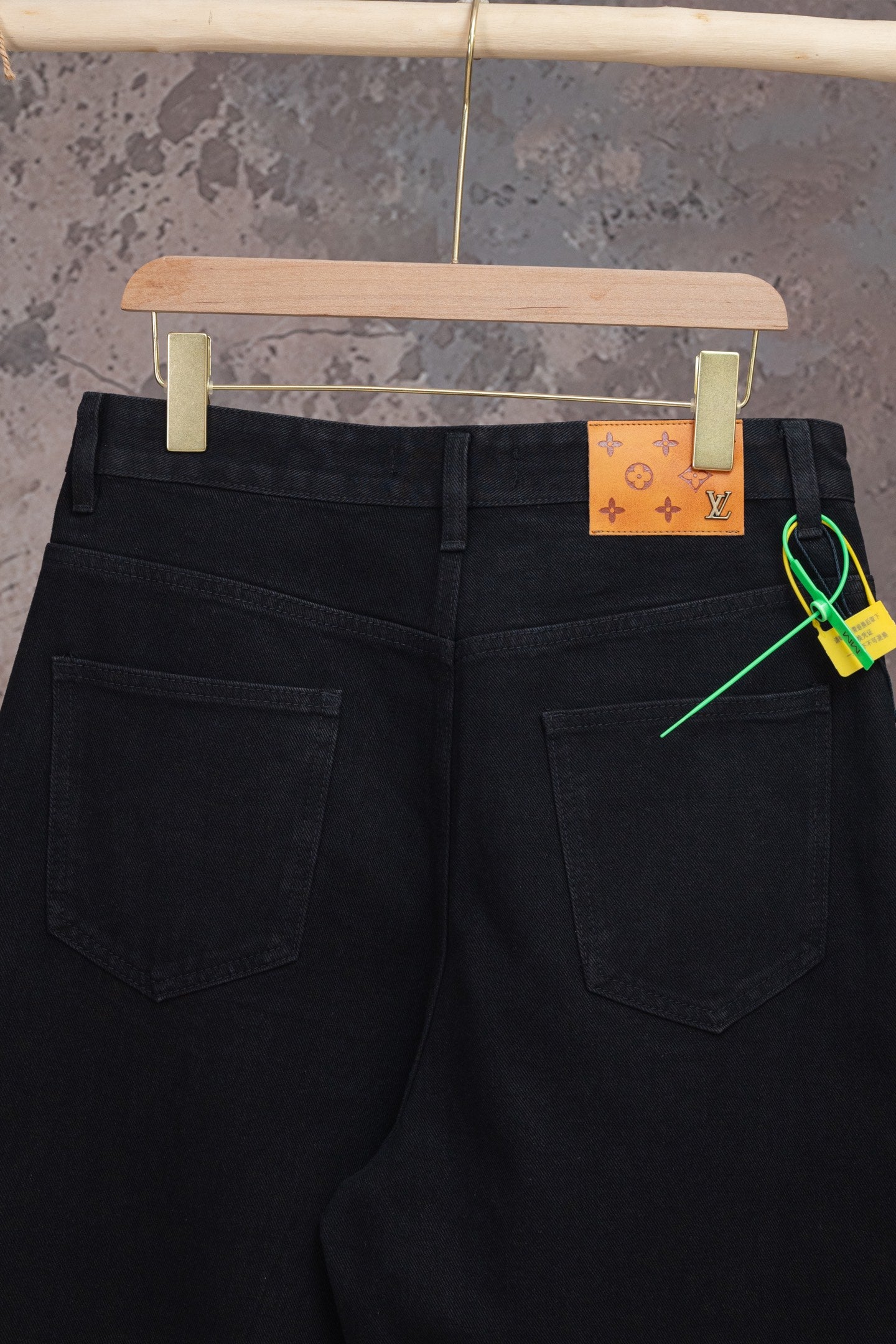 Black Louis Vuitton jeans with dual pockets and orange waistband brand label
