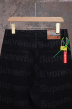 Black denim pants side view with pocket and hanging Supreme tag