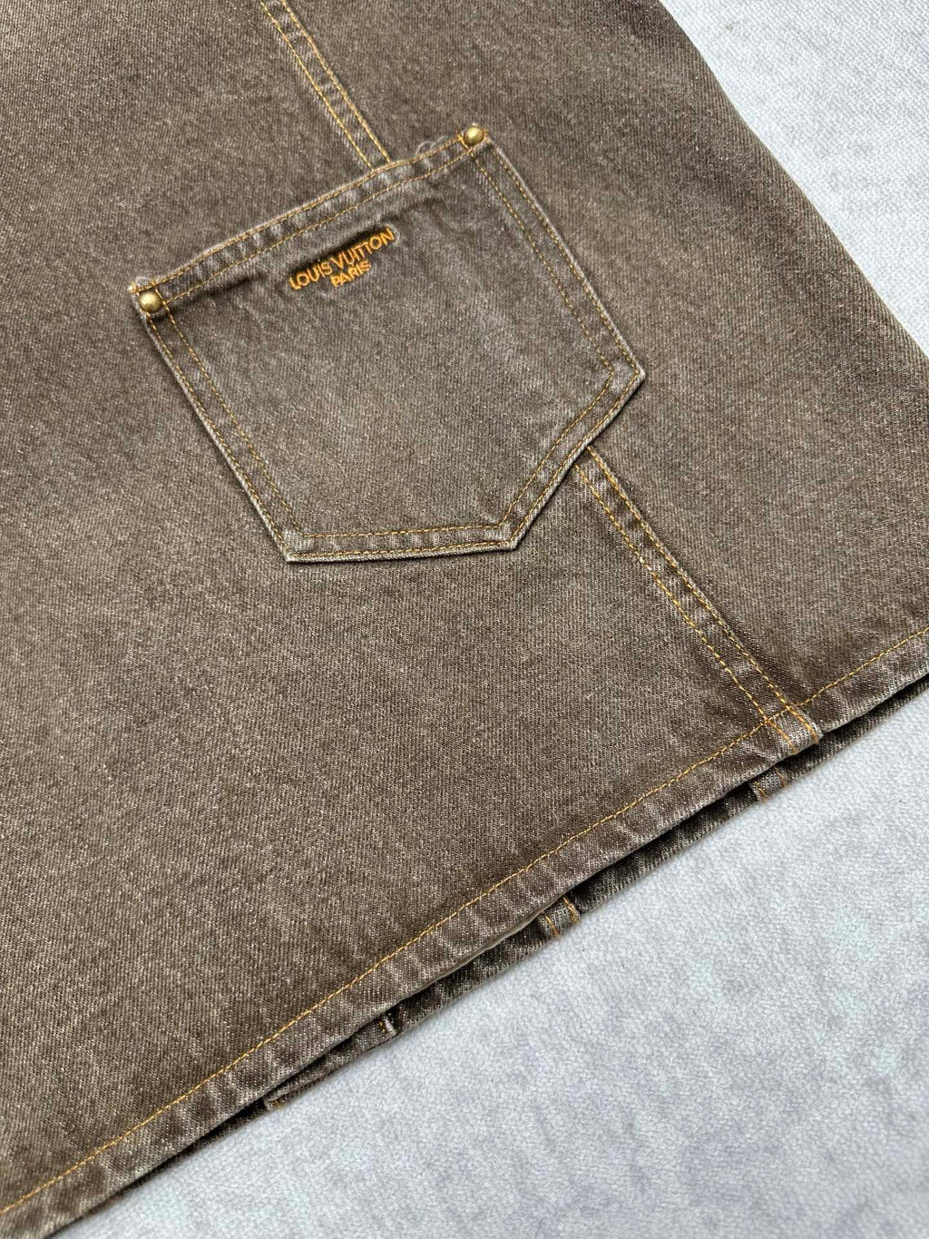 Dark gray denim jacket with side seam pocket and gold Louis Vuitton label patch